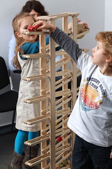 Kinder spielen im Wartezimmer mit der Kugelbahn